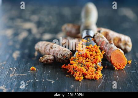 Racine de curcuma fraîchement moulue contenant de la curcumine, une substance anti-inflammatoire et antioxydante. Mise au point sélective avec arrière-plan flou. Banque D'Images