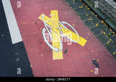 une piste cyclable marquée en rouge annulée avec une croix jaune dans une ville allemande Banque D'Images