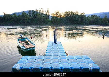 Un pêcheur à la ligne sur la rivière Drina au coucher du soleil à Bajina Basta, Serbie Banque D'Images