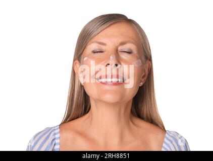 Belle femme âgée avec crème de protection solaire sur son visage isolé sur blanc Banque D'Images