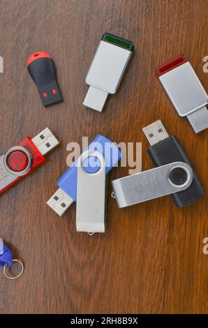 Gros plan de plusieurs clés USB sur la table en bois. Plusieurs clés USB différentes. Clés USB représentant le stockage mobile et la technologie de pointe. Banque D'Images