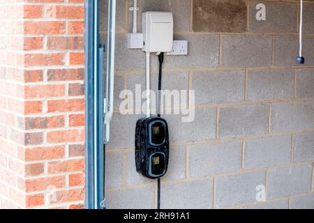 Point de charge domestique de véhicule électrique installé à l'extérieur de la maison sur le développement de nouveaux logements dans le cadre du programme d'énergie verte pour permettre la recharge Banque D'Images