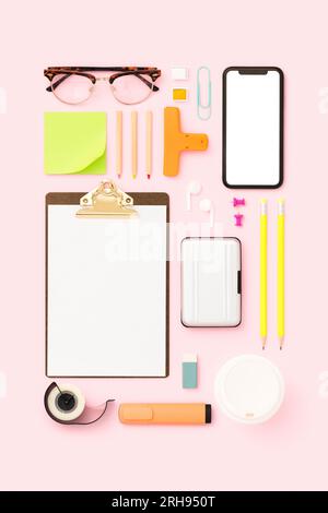 Les choses sur mon bureau, la papeterie, la rentrée à l'école à plat. Maquette de smartphone avec écran d'espace de copie vierge sur fond rose Banque D'Images