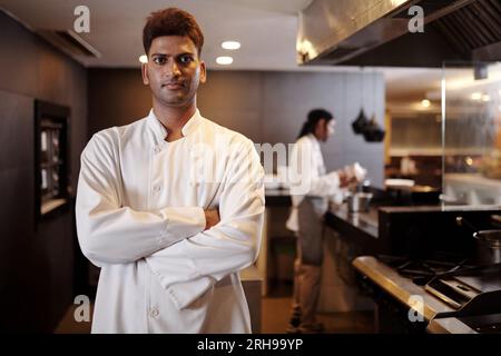 Portrait d'un chef de restaurant confiant en uniforme blanc debout dans un kinchen de fantaisie Banque D'Images