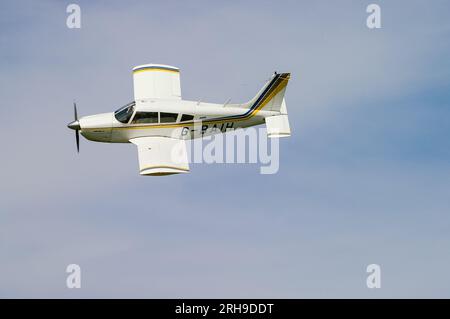 Piper PA-28 Cherokee Arrow II G-BAIH avion léger volant une bonne visibilité. Aviation générale vol privé. Vieux, petit avion monomoteur Banque D'Images