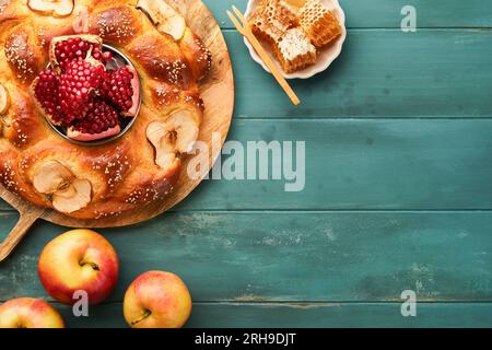 Fêtes juives - Rosh Hashana ou Rosh Hashana. Grenade, pommes, miel et challah rond sur fond de table bleu en bois vieux. Célébrité juive d'automne Banque D'Images