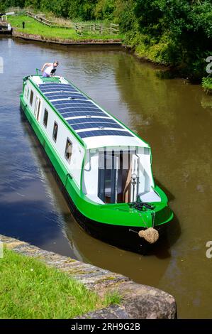 bateau électrique narrowboat appelé Electric Dragon naviguant le long d'un canal dans le Worcestershire sous le soleil d'été. Banque D'Images