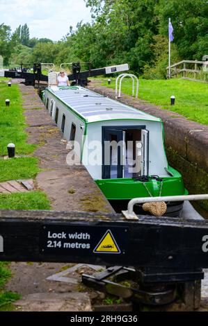 bateau électrique narrowboat appelé Electric Dragon naviguant le long d'un canal dans le Worcestershire sous le soleil d'été. Banque D'Images