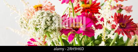 Bouquet d'été de Zinnia colorée, inflorescences d'oignon et brins de menthe, bouquet de fleurs sur la table près du mur, bannière de fleurs Banque D'Images