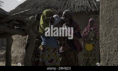 maman africaine portant son enfant sur le dos. Montrer la belle maternité des Africains. les mères portant leurs enfants. Banque D'Images