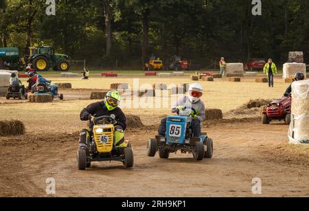 Les pilotes de tondeuse à gazon de course se bousculent pour se positionner au lever du soleil après avoir roulé toute la nuit dans la BLMRA 500, une course de tondeuse à gazon de nuit de 500 miles style le Mans Banque D'Images