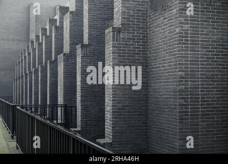 Murs extérieurs du Gdański Teatr Szekspirowski (Théâtre Shakespeare Gdańsk). Ailerons de brique ou renfort sur façade grise Banque D'Images