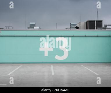 niveau supérieur du parking couvert. Plus arbre est écrit sur le mur turquoise Banque D'Images