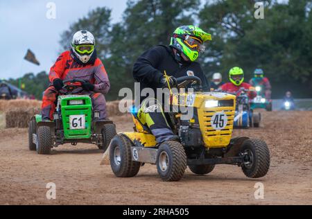 Les pilotes de tondeuse à gazon de course se bousculent alors qu'ils prennent un virage à l'aube dans la BLMRA 500, une course de tondeuse à gazon d'endurance de 500 miles style le Mans dans une fie Banque D'Images