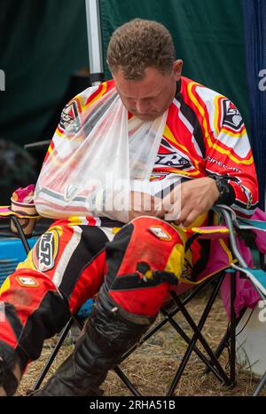 Un pilote de tondeuse à gazon de course de 'Nemo Racing' qui s'est cassé la collerette dans un accident dort au lever du soleil à côté de la piste de la BLMRA 500, a le Mans Banque D'Images