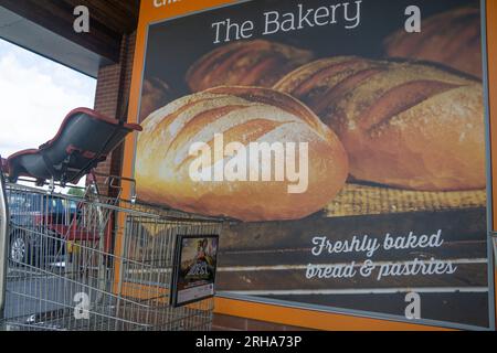 Affiche publicitaire de boulangerie avec chariot et siège bébé à l'extérieur de Sainsbury's, Chiswick, Londres Banque D'Images