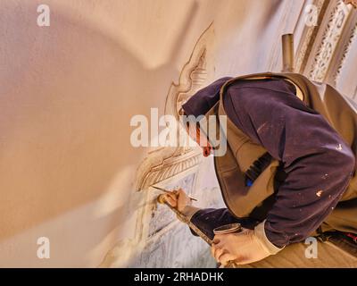 artiste féminine faisant la restauration de peinture ancienne. Peinture murale Restauration historique préservation historique réparation d'un ancien bâtiment Banque D'Images