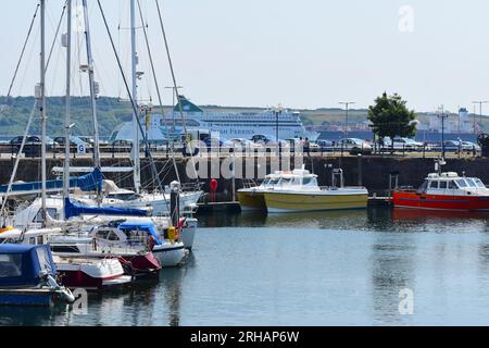 Au-delà du mur du port de Milford Haven Marina, les Irish Ferries, Oscar Wilde, descendent le havre en direction de la mer après avoir quitté Pembroke Dock Banque D'Images