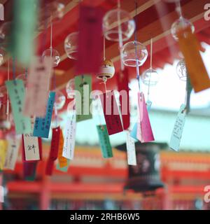 De nombreux carillons Tanabata Wind colorés pendent du haut du plafond avec des souhaits écrits en japonais. Dans un sanctuaire en été Kyoto Japon Banque D'Images