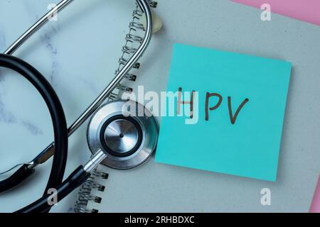 Concept de HPV écrire sur des notes adhésives avec stéthoscope isolé sur la table en bois. Banque D'Images