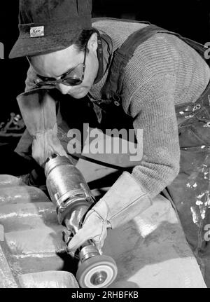 New York, New York : 1940 Isamu Noguchi travaille sur l'Associated Press Building plaque, qui a été sculptée dans le plâtre et coulée en acier inoxydable - à l'époque la plus grande coulée d'acier inoxydable jamais réalisée. Il est toujours installé au Rockefeller Center. Banque D'Images