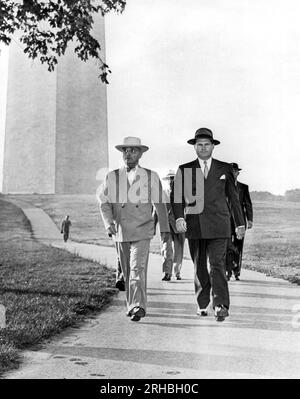 Washington, DC : 1946 le président Truman avec son entourage des services secrets lors d'une promenade rapide à travers le Washington Monument Grounds. Banque D'Images