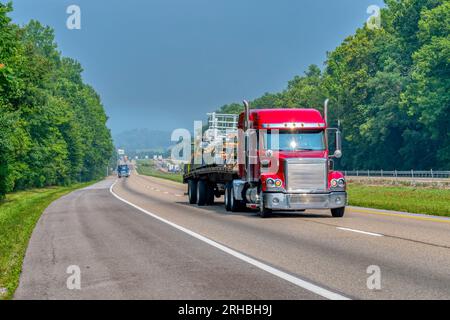 Plan horizontal d'un dix-huit roues à plateau transportant des matériaux de construction sur une autoroute inter-États. Banque D'Images
