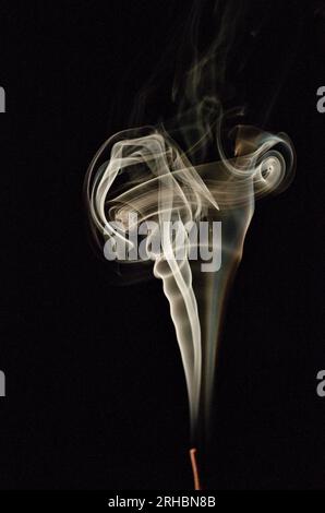 Photo abstraite du mouvement d'arrêt de fumée de cigarette isolé sur fond noir foncé. Amusez-vous avec la fumée. Banque D'Images