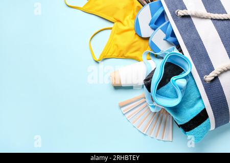 Sac femelle avec différents accessoires de plage sur fond de couleur Banque D'Images