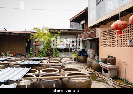 La cour principale de l'usine de sauce soja maison Hao Yong Seng où les graines de soja dans de grands récipients sont fermentées par le soleil, pendant quatre à cinq mois, à Khlong Bang Luang, communauté historique le long du canal. "Hao Yong Seng" est la seule usine de sauce soja maison restante à Bangkok, depuis 3 générations, depuis plus de 100 ans, la famille n'a jamais changé la formule et maintient toujours le processus de fabrication traditionnel qui prend jusqu'à 6 mois pour obtenir une bouteille, dans la communauté de Khlong Bang Luang qui était autrefois un quartier économique, c'est la seule usine de sauce soja qui reste. Banque D'Images