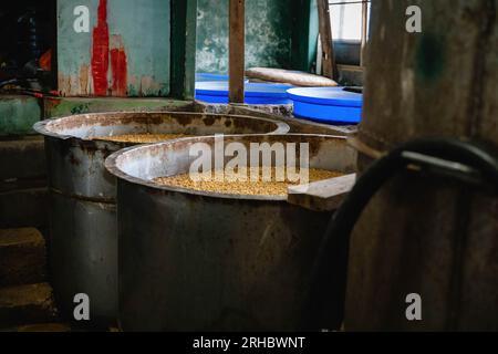 Bangkok, Thaïlande. 15 août 2023. Soja fermenté dans de grands récipients qui attendent d'être bouillis avec du bois pendant 12 heures, puis filtré et mis en bouteille, à l'usine de sauce soja maison Hao Yong Seng du siècle, à Khlong Bang Luang, communauté historique le long du canal. 'Hao Yong Seng'' est la seule usine de sauce de soja maison restante à Bangkok, depuis 3 générations, depuis plus de 100 ans, la famille n'a jamais changé la formule et maintient toujours le processus de fabrication traditionnel qui prend jusqu'à 6 mois pour obtenir une bouteille, dans Khlong Bang Luang communauté qui était autrefois un économique Banque D'Images