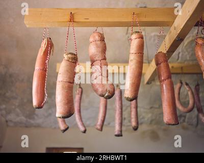 D'en bas d'un ensemble de saucisses maison dans des boyaux de porc attachés avec des cordons culinaires suspendus sur des poutres en bois pour le séchage à Matanza à Majorque Banque D'Images