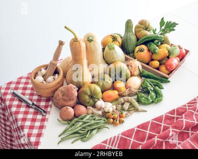 D'en haut composition de citrouilles fraîches et de tomates avec des pommes de terre placées près des oignons mûrs et des tartes à l'ail en pile sur la table blanche et le bol près Banque D'Images