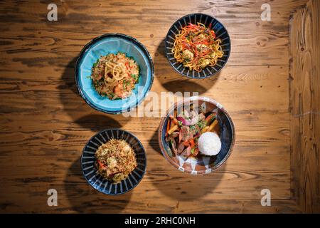 Vue de dessus des bols de différents plats de riz frit épicé avec des légumes faire sauter le bœuf avec des carottes bouillies riz cuit et pâtes spaghetti avec de la viande Banque D'Images