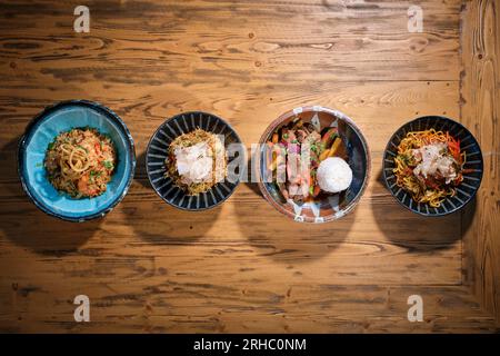 Vue de dessus des bols de différents plats de riz frit épicé avec des légumes faire sauter le bœuf avec des carottes bouillies riz cuit et pâtes spaghetti avec de la viande Banque D'Images