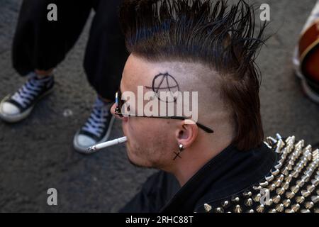 Un jeune homme avec un mohawk sur la tête est assis dans une cour d'une maison dans le centre de Moscou, en Russie Banque D'Images