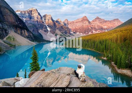 Femme prenant une photo, lac Moraine en été dans le parc national Banff, Rocheuses canadiennes, Alberta, Canada. Parc national Banff, Alberta, Canada Banque D'Images