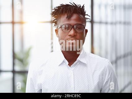Portrait de tête jeune homme africain sérieux portant des lunettes regardant l'appareil photo Banque D'Images