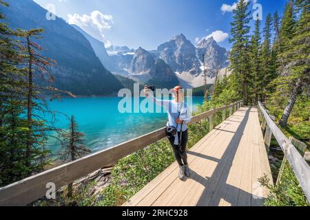 Femme prenant un selfie, lac Moraine pendant l'été dans le parc national Banff, Rocheuses canadiennes, Alberta, Canada. Parc national Banff, Alberta, Canada Banque D'Images