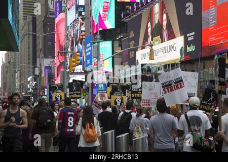 New York City : la grève se poursuit parmi les Writers Guild of America et les membres du syndicat SAG-AFTRA avec des lignes de piquetage dans plusieurs endroits de Manhattan. Les membres du syndicat manifestent le long de Broadway à Times Square, paralysant l'industrie du divertissement. Banque D'Images