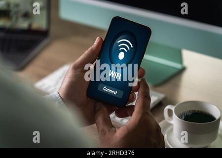 gros plan homme à l'aide d'un smartphone avec icône wifi bouton de réseau social de communication pour se connecter à internet sans fil Banque D'Images