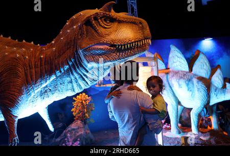 Holon, Israël. 15 août 2023. Les gens visitent une exposition de dinosaures modèles à Holon, dans le centre d’Israël, le 15 août 2023. Des dizaines de modèles de dinosaures grandeur nature de différentes périodes sont présentés à l'exposition, offrant aux enfants une expérience d'apprentissage interactive. Crédit : Gil Cohen Magen/Xinhua/Alamy Live News Banque D'Images