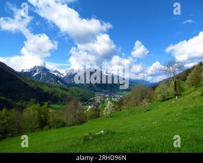 Vue d'une petite ville alpine Kranjska Gora dans les alpes juliennes et le parc national du Triglav, Gorenjska, Slovénie et le sommet enneigé de la montagne s'élevant au-dessus d'an Banque D'Images