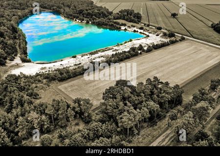 Photographie aérienne aliénée d'un étang de gravier entre champs et forêts Banque D'Images