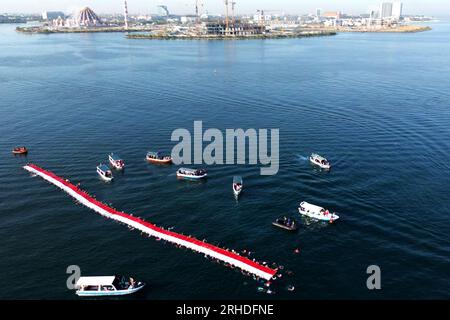 Jakarta, Indonésie. 12 août 2023. Cette photo aérienne montre des nageurs déployant un drapeau national indonésien de 78 mètres de long avant le 78e jour de l’indépendance à Makassar, Sulawesi du Sud, Indonésie, le 12 août 2023. Le 17 août marque le jour de l'indépendance de l'Indonésie. Crédit : Niaz Sharief/Xinhua/Alamy Live News Banque D'Images