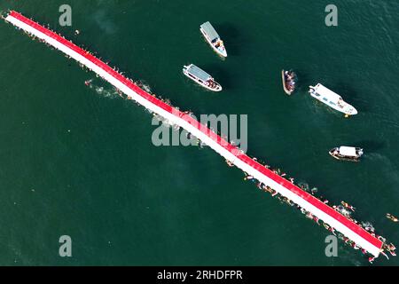 Jakarta, Indonésie. 12 août 2023. Cette photo aérienne montre des nageurs déployant un drapeau national indonésien de 78 mètres de long avant le 78e jour de l’indépendance à Makassar, Sulawesi du Sud, Indonésie, le 12 août 2023. Le 17 août marque le jour de l'indépendance de l'Indonésie. Crédit : Niaz Sharief/Xinhua/Alamy Live News Banque D'Images