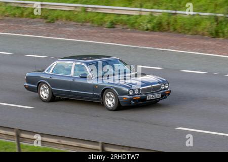 Années 1999 90 gris Jaguar Sovereign V8 Auto XJ8 SWB Auto Saloon essence 3996 cc roulant à grande vitesse sur l'autoroute M6 dans le Grand Manchester, Royaume-Uni Banque D'Images