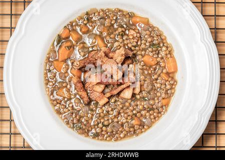 Soupe de lentilles avec porc et carottes dans le bol blanc Banque D'Images