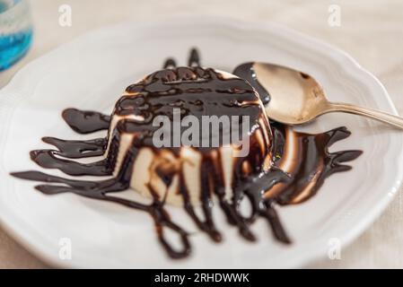 Dessert italien Panna Cotta avec sauce au chocolat sur plaque blanche Banque D'Images