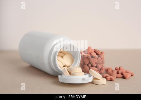 Différentes vitamines pour animaux de compagnie sur la table beige, closeup Banque D'Images